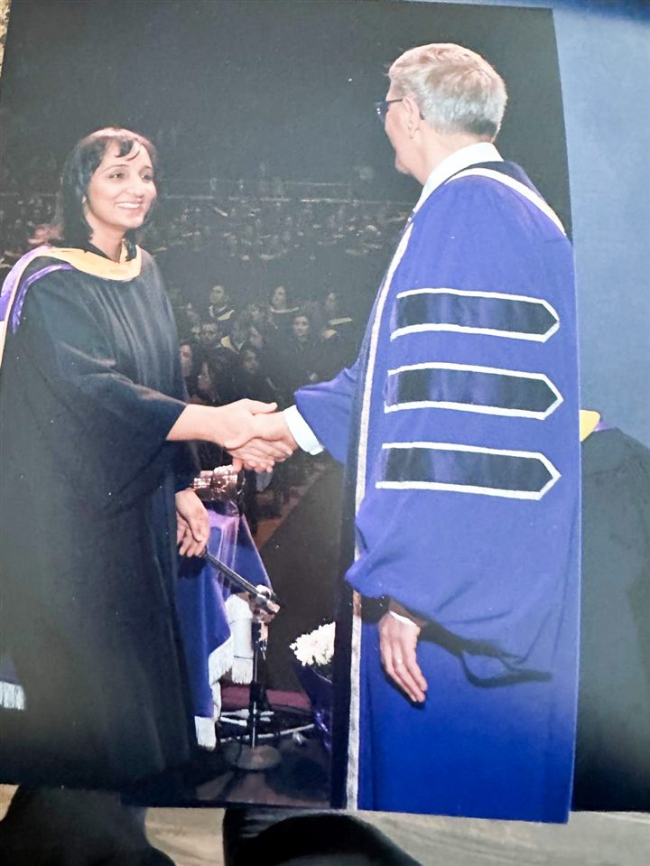 Ravinder Kaur Sidhu shaking hands on stage while receiving her degree at convocation